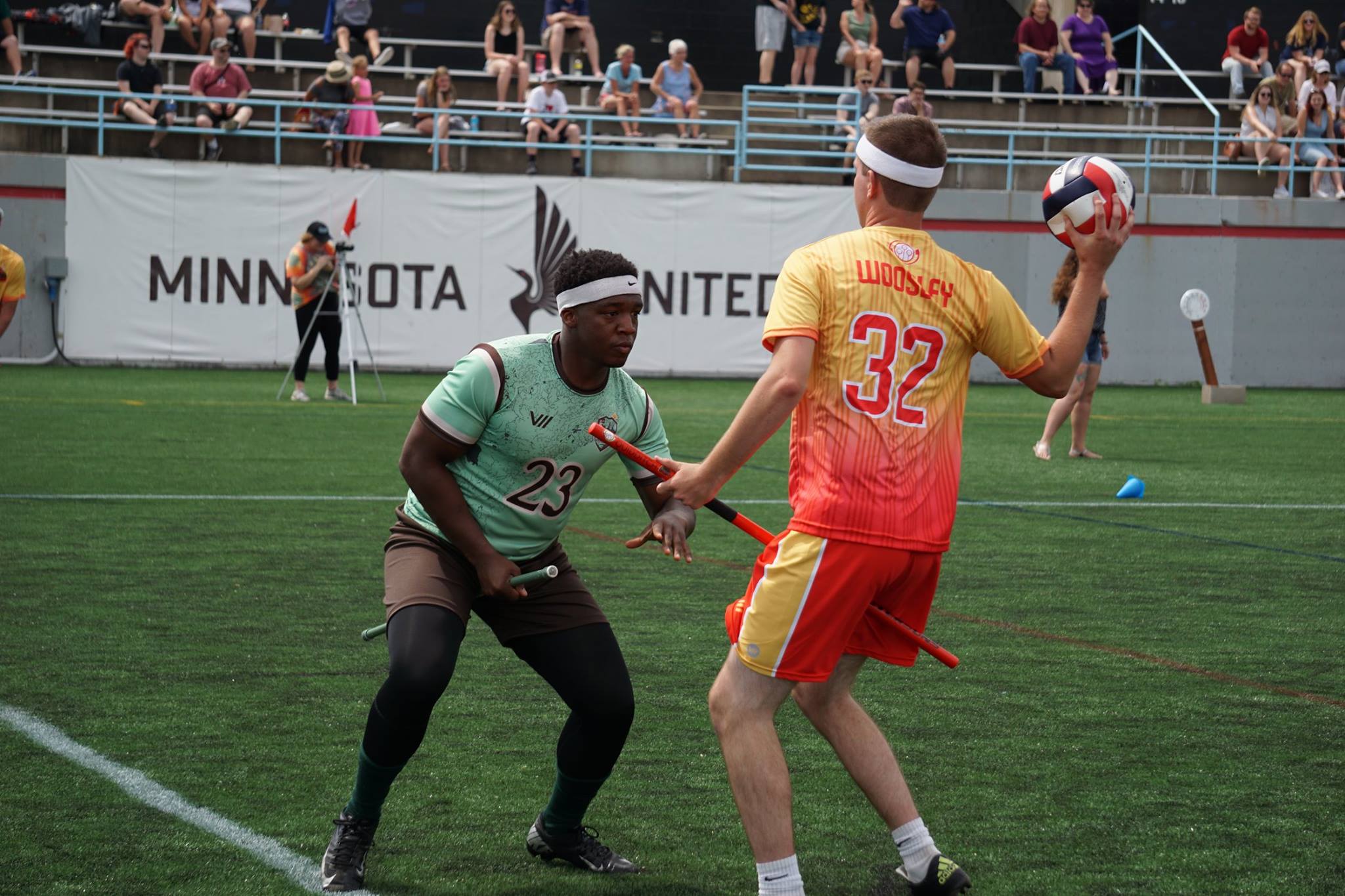 A chaser looks to pass the quaffle while being defended by a beater in a game of quidditch.