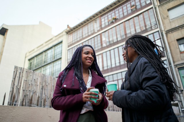 Two businesswomen drink coffee.