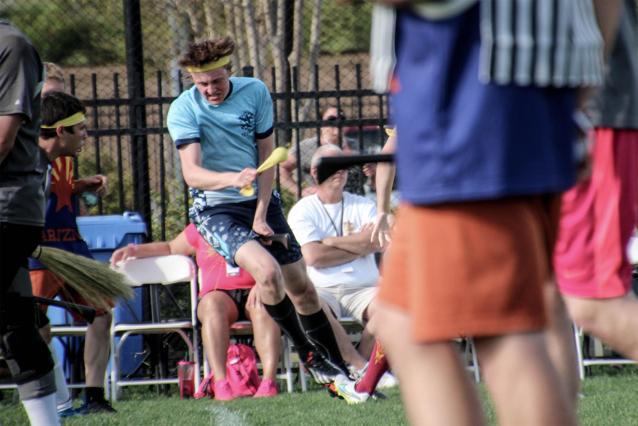 A seeker pulls a yellow sock with a tennis ball inside to capture the “snitch” and give his quidditch team a victory. 