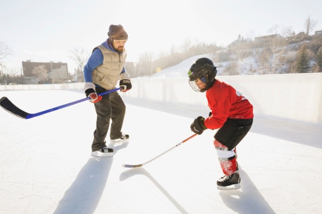 coach and youth athlete playing hockey red jersey