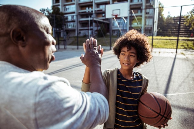 Grandpa and youth basketball player high five